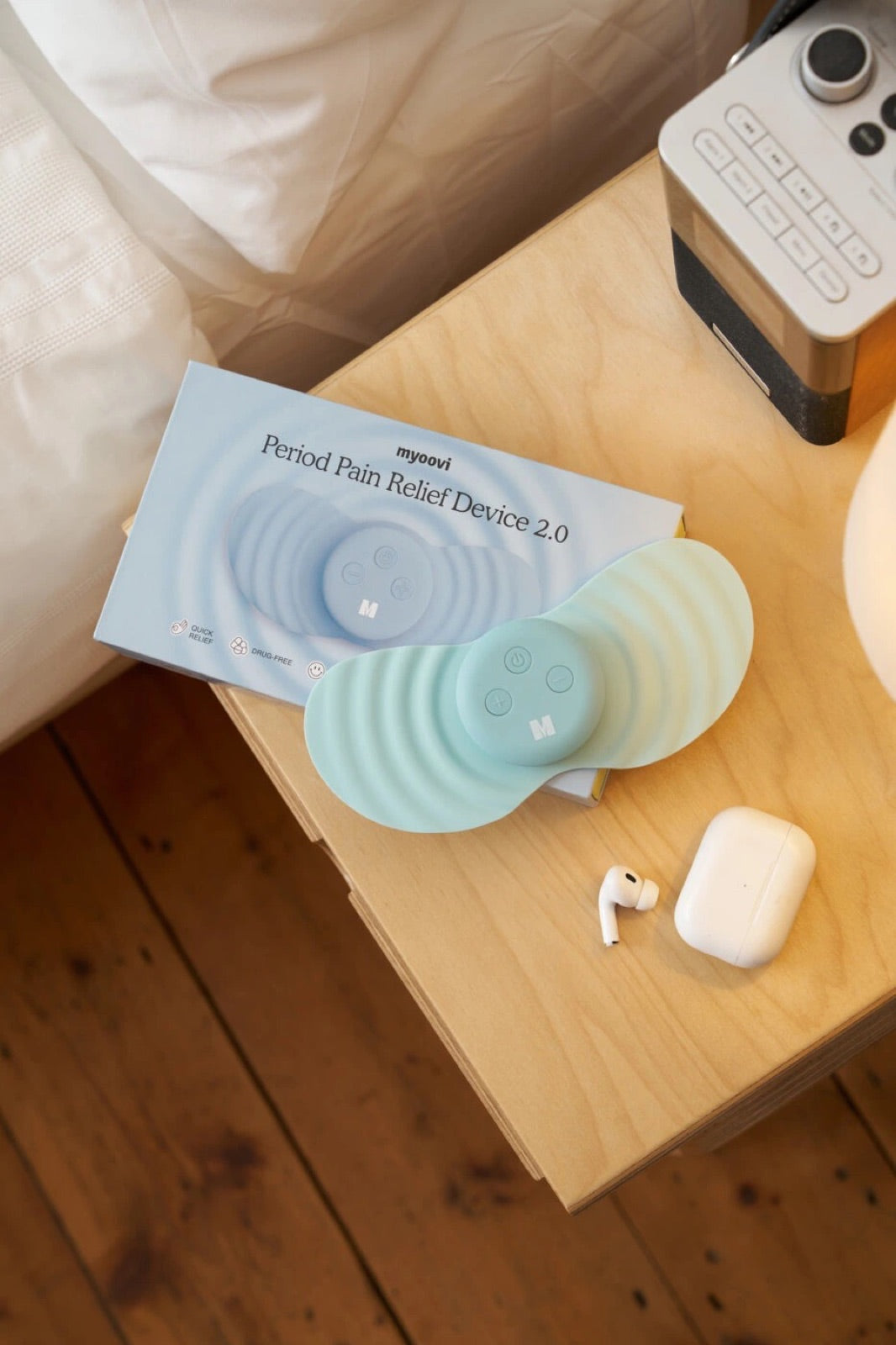Myoovi 2.0 device and box on a wooden bedside table