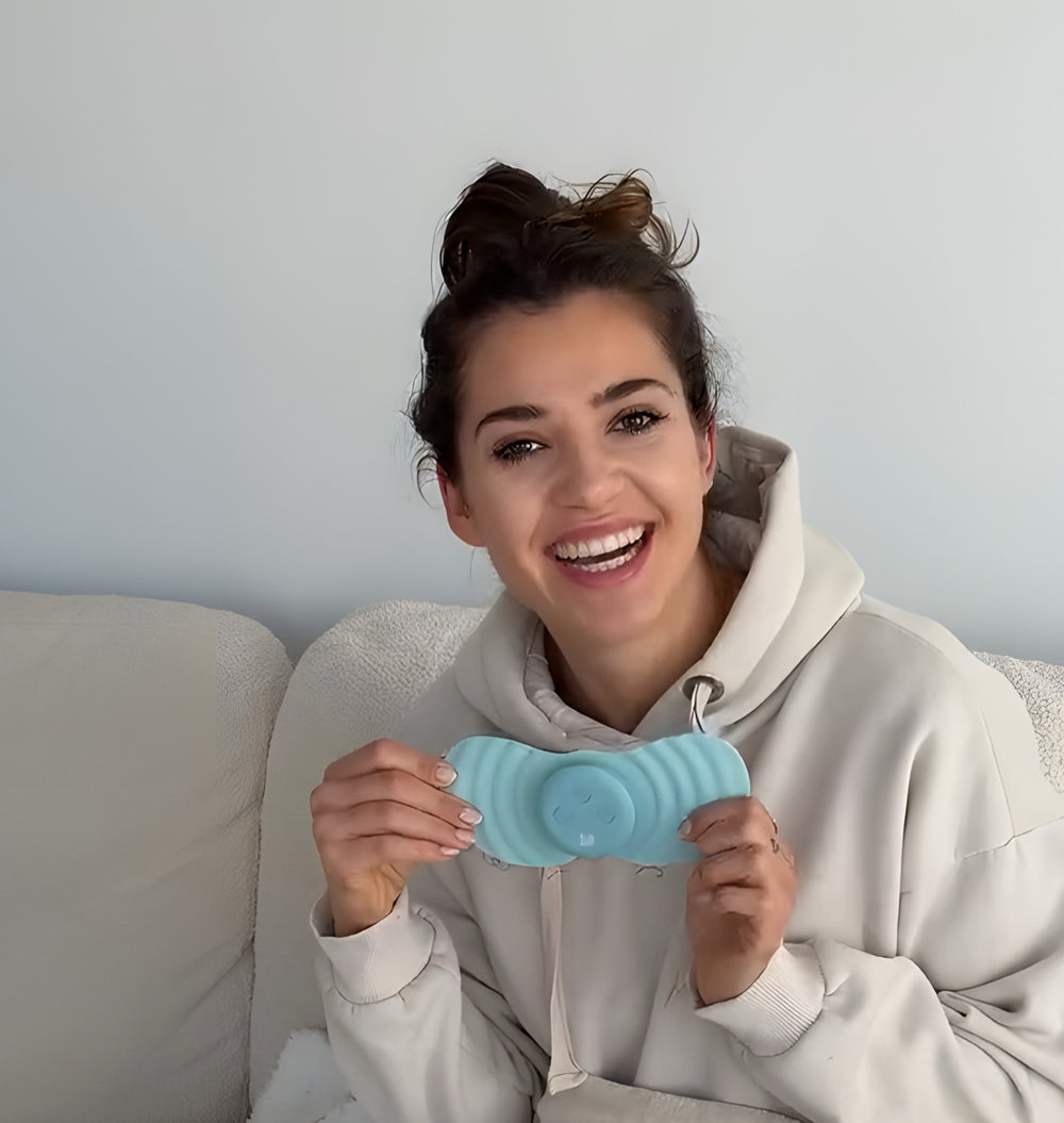 Smiling woman on a sofa holding the Myoovi 2.0 device